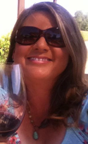 Lisa Rush holding a wine glass and smiling.